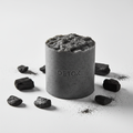 Charcoal detox bar soap with activated charcoal pieces on a white background